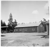 Vägstation I5, Stånga. Baksidan av garagebyggnaden. Diverse materialupplag.