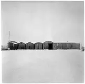 Vägstation M7, Dalby. Ett antal små förrådsbyggnader i korrugerad plåt. Manskapsvagn till vänster.