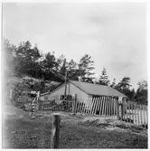 Vägstation O6 a &b, Dingle, filial Rörby. Garagebyggnad, innanför trästaket.