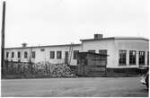 Vägstation P2, Kinna. Vägstationens huvudbyggnad med från höger verkstad, kontor och garage (baksidan). Upplag av storgatsten alternativt träkubb.