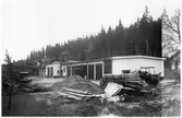 Vägstation P16, Bengtsfors. Vägstationens huvudbyggnad med verkstad, kontor och garage. Bortom denna byggnad äldre byggnad med skylt på framsidan 