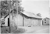 Vägstation S9 Kil, filial Edsvalla. Garagebyggnad av korrugerad plåt. Spetsplog på baksidan av byggnaden. Invid väg.