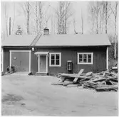 Depåförrådet i Ånstaberg (Vägstation T5). Kontors- och förrådsbyggnad. Stationär motor stående framför byggnaden, brandsläckare på väggen.