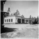 Vägstation T6, Nora. Vägstationens huvudbyggnad med verkstad, kontor och garage. Väghyvel på garageplan.