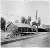 Vägstation T7, Frövi, filial Glanshammar. Garagebyggnad och förrådsbyggnad, invid väg. Telefonstolpe vid vägen.