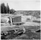 Vägstation T8, Grythyttan, filial Kopparberg. Vägstationens grusgrop med olika små förrådsbyggnader, diverse material.