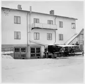 Vägstation U5, Heby, filial Tärnsjö. Garage i källarvåningen till ett tvåvånings bostadshus. Cykelställ med cyklar.