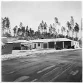 Vägstation U7, Kolbäck. Filial Ramnäs. Garagebyggnad med kontor i vänstra delen. Förrådsbyggnad med cykelställ med cyklar vid gaveln. Spetsplog, sidoplogar. Bensinpump (drivmedelspump). Invid väg.