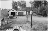 Vägstation W3, Smedjebacken, filial Grängesberg. Garage- och förrådsbyggnader. På garageplan spetsplog och rivare, June (till höger). Bensinpump (drivmedelspump) Ljungmans, modell Vici. Två personbilar.