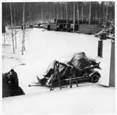 VFW, Depåförråd (Vmo W6). Vy över garageplan. Öppen förrådsbyggnad (skjul) i bakgrunden. Diverse olika väghållningsmaskiner och fordon, bland annat schaktmaskin (under presenning på flak), sten- och stubbrytare,  bensinpump (drivmedelspump).