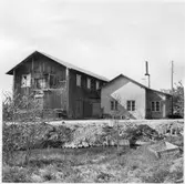 Vägstation Vmo X3, Söderala. Två sammanbyggda förrådsbyggnader. Byggnad till höger med reveterad fasad, eventuellt smedja.