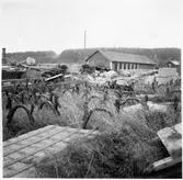 Vägstation Vmo X4, Bollnäs. Skrotupplag. I bakgrunden tegelbyggnad som tillhörde Vägförvaltningen i Gävleborgs län, Depåförrådet.