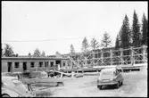Vägstation Y1, Ånge. Byggande av ny vägstation. Kontors- och förrådsbyggnad. Personbilar i förgrunden, Saab B79415 och Volkswagen.