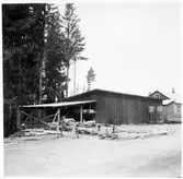 Vägstation Y1, Östavall. Förrådsbyggnad. Upplag av trävirke.