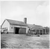 Vägstation Y3, Matfors. Verkstads-, kontors- och garagebyggnad. Vid gavel cykelställ med cyklar. På garageplan traktor och hopfälld väghållningsmaskin, eventuellt ett grussorteringsverk.