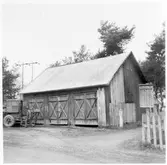 Vägstation Y3, Matfors, filial Bergsåker. Garagebyggnad. Till vänster väghyvel och en mansperson. Invid väg.