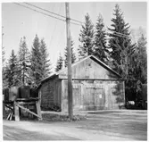 Vägstation Y4, Liden, filial Kovland. Garagebyggnad, med portar på gaveln. Byggnad delvis i liggtimmer, eventuellt gammal lada. Till vänster 