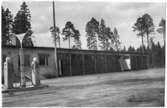 Vägstation Y5, Timrå. Garagebyggnad, till vänster kontorsbyggnad. Bensinpumpar (drivmedelspumpar). Skylt vid pumparna 
