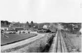 Depåförrådet i Älandsbro (Vägstation Y6). Depåförrådet (närmast järnvägen). Till vänster huvudbyggnaden för vägstationen Y6 Älandsbro och depåverkstaden (länsverkstaden). På garageplan olika väghållningsmaskiner och väghållningsredskap, bland annat grussorteringsverk, stenkross, vält, spetsplogar. I bakgrunden bostadshus och bondgård. Invid järnväg.