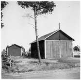 Vägstation Y9, Själevad, filial Hemling. Garagebyggnad, i bakgrunden förrådsbyggnad och bostadshus. Invid väg.