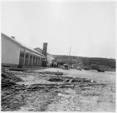 Vägstation Y10, Arnäsvall. Vägstationens huvudbyggnad med garage, kontor och verkstad. På garageplan två personbilar, manspersoner, spetsplog.