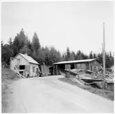 Vägstation Y11, Nyland. Förrådsbyggnader och eventuell garagebyggnad. Spetsplog vid vägkanten, cyklar. Byggnaden med skorsten eventuell smedja (verkstad).
