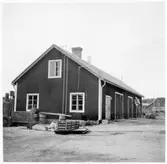 Vägstation Y13, Bredbyn. Garage- och förrådsbyggnad. Vägmärken lutade mot byggnaden.