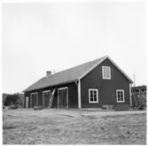 Vägstation Y13, Bredbyn.  Garage- och förrådsbyggnad. Vägmärken lutade mot byggnaden.