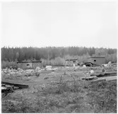 Y län. Före detta hamnförrådet. Förrådsbyggnader. Upplag av diverse material runt byggnaderna, bland annat cementrör.