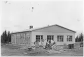 Vägstation Z9, Nälden, filial Oviken. Garagebyggnad, under uppförande. Markberedning av garageplan pågår. Cement- och betongblandare, skottkärra.