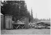 Vägstation Z13, Gäddede. Mindre förrådsbyggnader. Upplag av bränslefat.