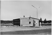 Vägstation AC5, Vindeln. Byggnad, troligen drivmedelsförråd. Bensinpumpar (drivmedelspumpar). Hög belysningsmast.