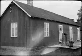 Vägstation AC9, Skellefteå, färjvaktarbostad Örviken. Förrådsbyggnad med vattenbrunn framför.