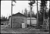 Vägstation AC14, Lycksele, filial Norrmalm.  Garage- och förrådsbyggnad. Vedupplag i bakgrunden. Upplag av diverse materiel, 