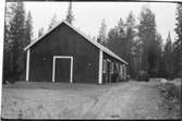 Byggnadsförrådet i Vilhelmina (Vägstation AC18). Förrådsbyggnad. Liten lastbil (paketbil) framför byggnaden.