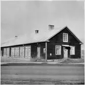 Vägstation BD4 Boden, Svartbjörnsbyn. Garagebyggnad. Kontor och förråd i främre gaveln. Cykel mot väggen. Invid väg.