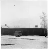 Vägstation BD14, Vittangi, filial Laxforsen. Garagebyggnad. Personbil framför byggnaden (vinterbild).