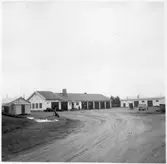 Vägstation BD16, Nattavaara. Vägstationens huvudbyggnad. Från vänster verkstad, kontor, garage. Förrådsbyggnad till höger. Bensinpumpar (drivmedelspumpar). Personbil på garageplan. Sidoplogar framför verkstaden.