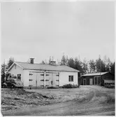 Vägstation BD18, Moskosel. Byggnad med garage och kontor. Till höger förrådsbyggnad. Personbil BD6152, cykelställ med cyklar utanför kontoret.