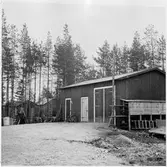 Vägstation BD18, Moskosel. Förrådsbyggnader. Upplag av diverse materiel vid byggnaderna. Cykelkärra.