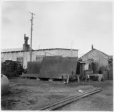 Kvarteret Stören, Luleå.  Förrådsbyggnader. Upplag av diverse materiel framför byggnaderna.