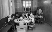 Vykort från förskolan i Stretereds skolhem (nuvarande Videgården), 1950-tal. Läraren Sonja Johansson sysselsätter fem pojkar med aktiviteter.