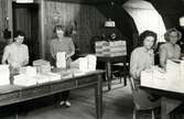 Rustika möbler i matsal som används som kontorslokal. Troligen bladas ett utskick till allmänheten, möjligen under andra världskriget. I bakgrunden syns ingång till två olika salonger.