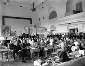 Kurs för folkskolelärare i Rosenfredsskolans aula. Längst till vänster: Åkerman. Mitt framför kartan lärare Fransson. Främre raden från höger: 1:a dam: Margareta Strömberg. Rakt fram i mitten: Olle Österberg, Thor Kärrdahl, slöjdlärare Hjalmar Johansson. Från höger i mitten: Rut Häggfors, 8 mot väggen: Fru Fransson, Engström, Ingegerd Linder.