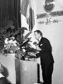Stenmans verkstadsklubb tjugofem-årsjubileum 1939-1964 på Folkets Hus i Alingsås.

Stig Olsson i talarstolen.