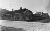 Källegatan mot väster x Österlånggatan med kvarteret Vesta. Byggmästare Ohlssons hus som på 1960-talet flyttades till Ramnaparken och blev kansli för muséet. 

I bakgrunden D G Rudholm & Co som tillverkade barnkläder. Fotot taget år 1925.
 Även kallad för Olssonska gården.