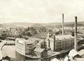 Wiskaholms fabrik i förgrunden med nybyggda svängda delen mot Viskan. Den låga svarta byggnaden på Krokshallstorget var 