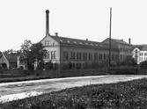 Evedals fabrik.

Från Frankrike kom Alois Béha. Han hyrde på 1880-talet det f.d. Gilckska färgeriets lokaler vid Västerbro men redan 1889 uppförde han, vid Viskan i norra delen av staden, en fastighet och startade egen färgeri- och blekerirörelse. Efter hustrun Eva fick fabriken namnet Evedal, något som lever kvar i såväl Evedalsbron som Evedalsgatan i dess närhet.

Efter flera konkurser övergick fabriken i Johan Skoglunds ägo men Béha stannade kvar som färg- och blekmästare. Senare finner vi honom som färgmästare på Nordens fabriker.

Hustrun Eva var konstnärligt och praktiskt lagd och startade på Östrlånggatan sin Rit- och Tapisseriverkstad.
