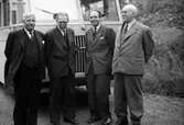 Fyra män står fram för en buss.
Från vänster: okänd, H.M. Enander, okänd, Georg Karlborg (målarmästare).