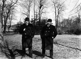 Från vänster: Otto Berggren och Fr. Lindqvist står på ett gräsfält med några träd i bakgrunden.